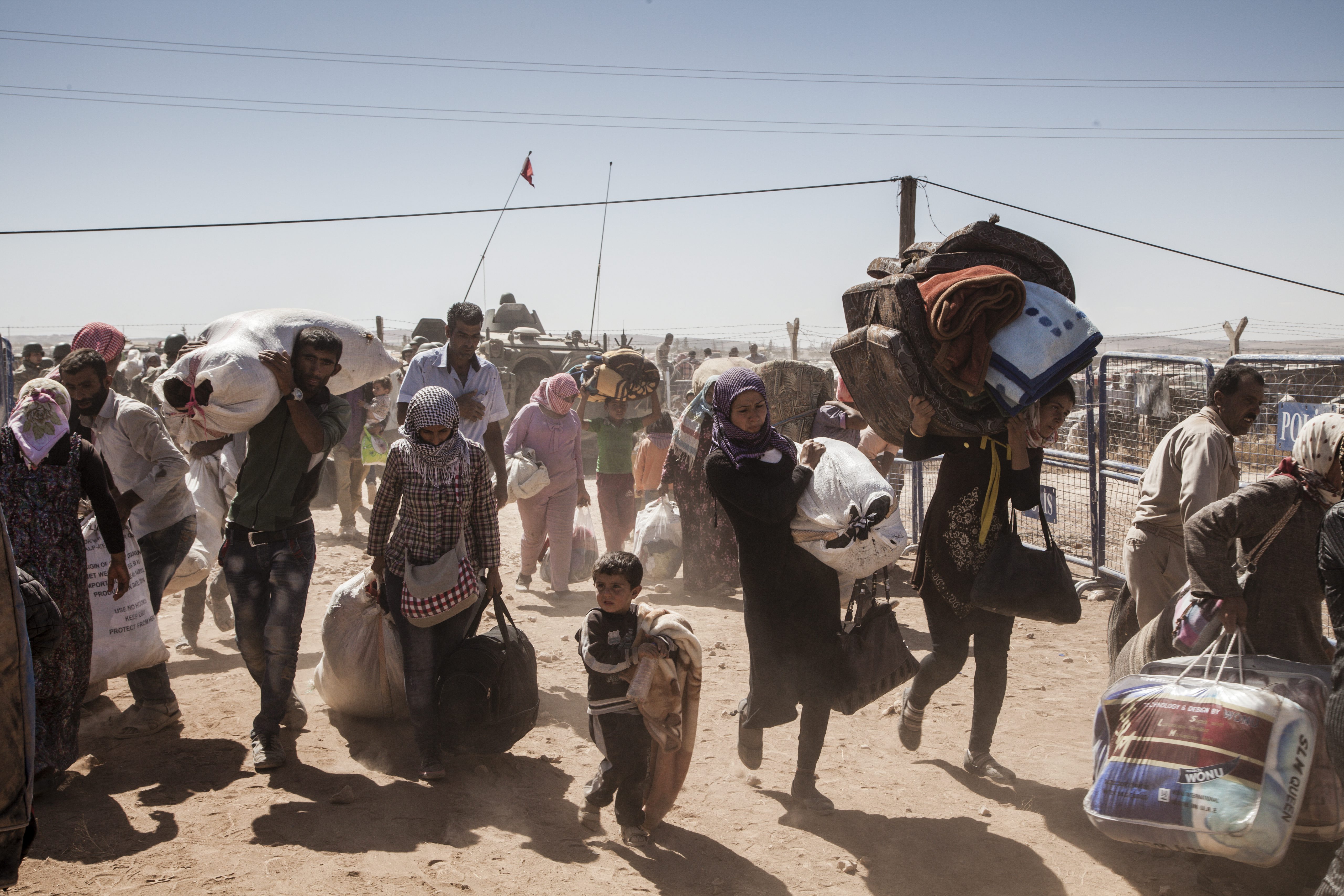 Geflüchtete syrische Kurden überqueren die syrisch-türkische Grenze nahe der Stadt Kobane. UNHCR / I. Prickett